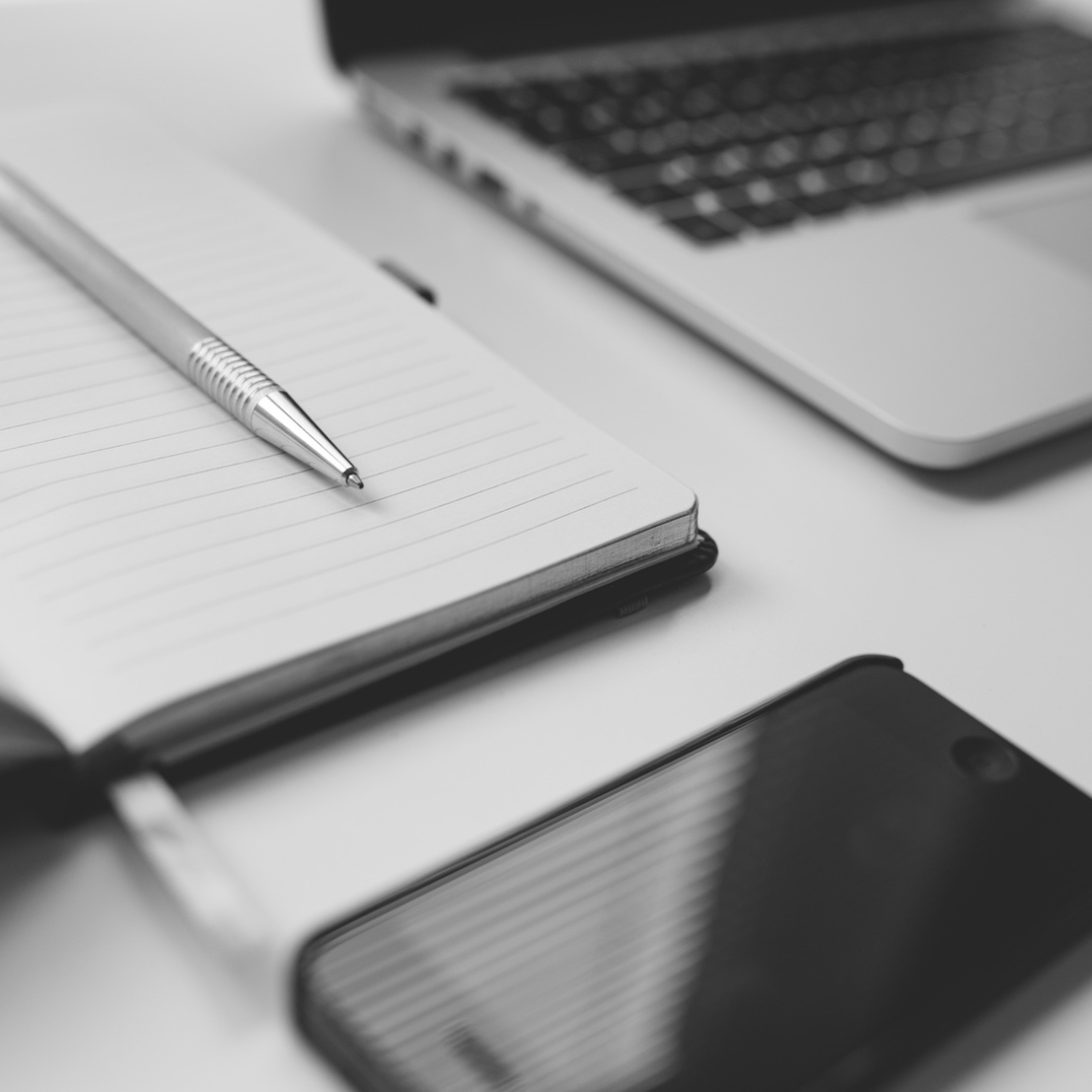 Laptop, notes, długopis i telefon na biurku